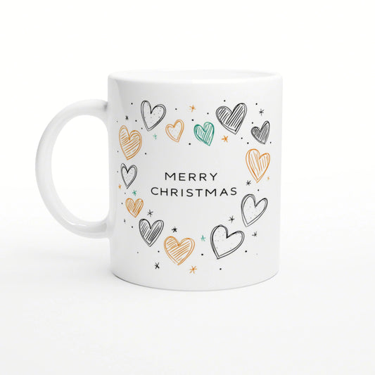 Product mockup: white ceramic mug with Merry Christmas text surrounded by hand-drawn multicolored hearts and tiny stars.