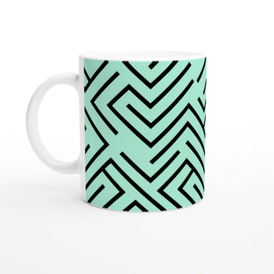 White mug with mint-green wraparound geometric maze pattern in bold black lines.