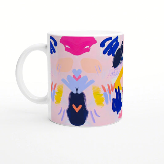 Product mockup: white mug with abstract painting on a pink background, featuring bold blue, yellow and orange brushstrokes.