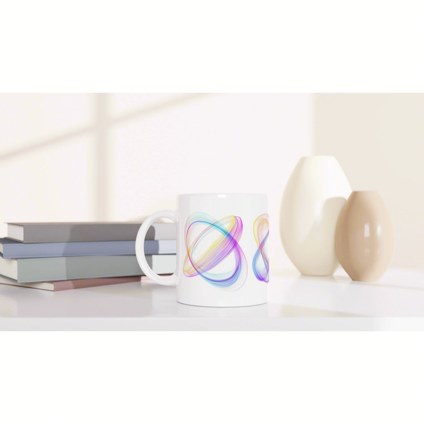 White ceramic mug with colorful abstract swirl design, placed on a shelf with books and vases in a soft neutral setting.