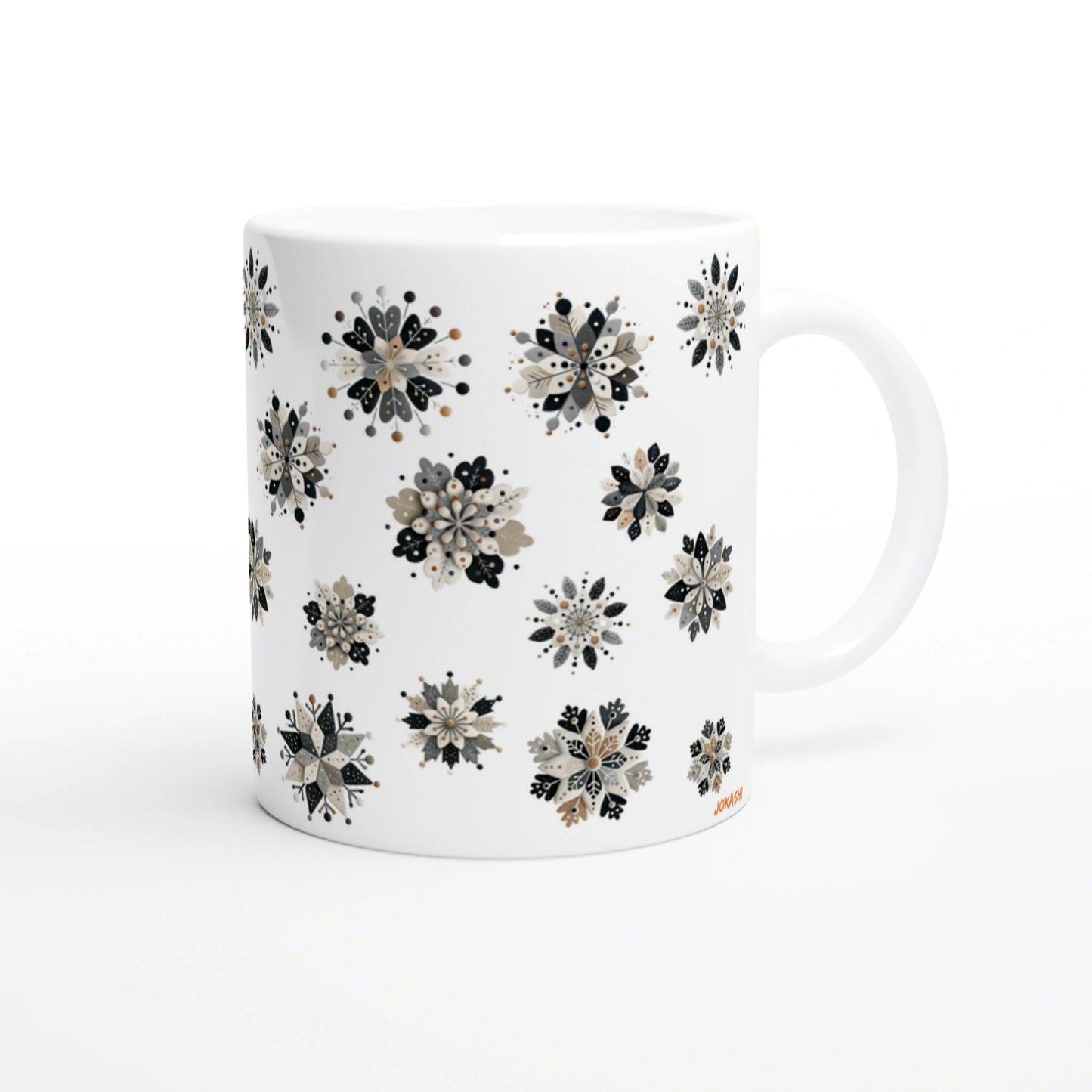 White ceramic mug with a repeating pattern of beige, black, and gray floral snowflake clusters; product mockup.