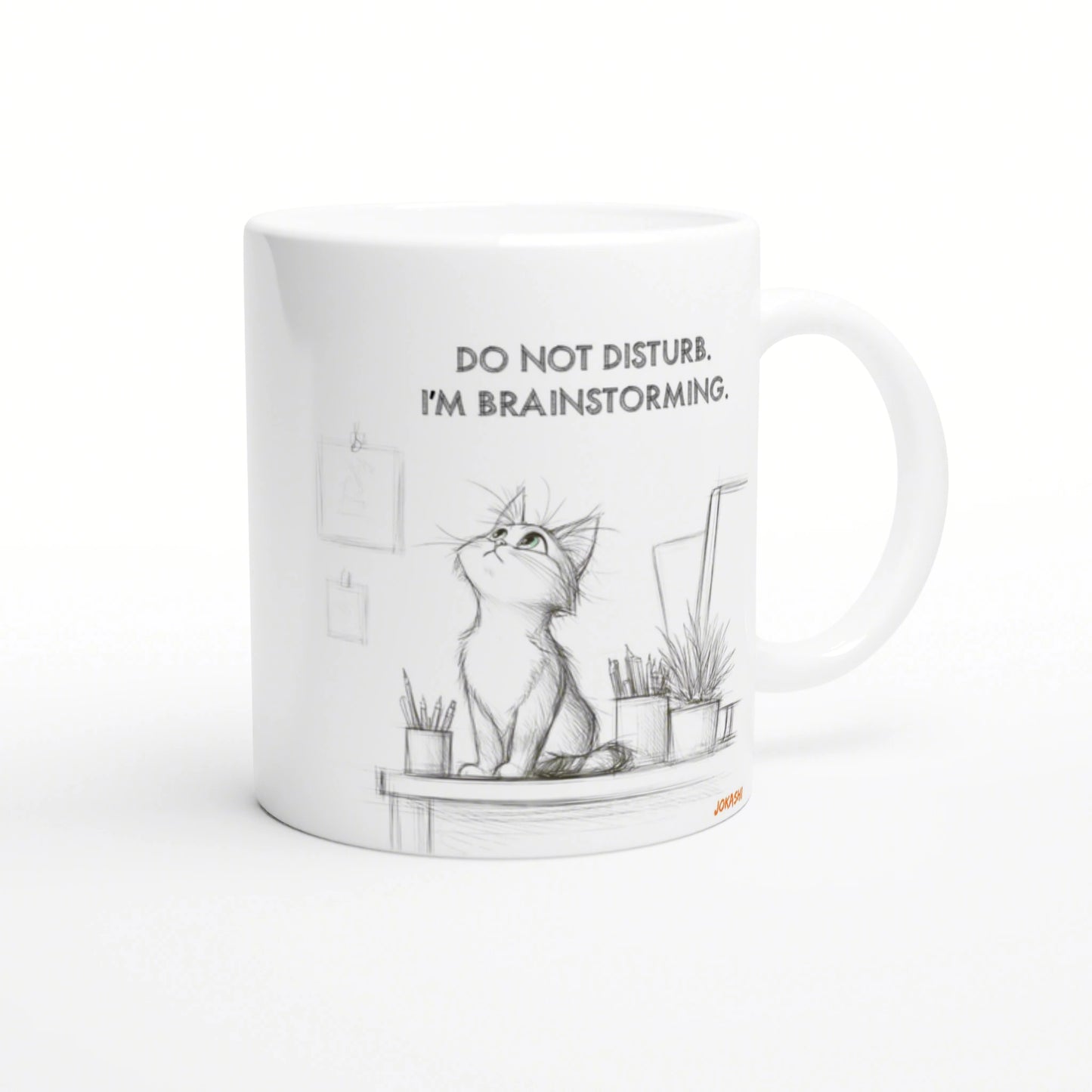 White ceramic mug with a pencil sketch of a cat on a desk, surrounded by plants, captioned Do not disturb. I'm brainstorming.