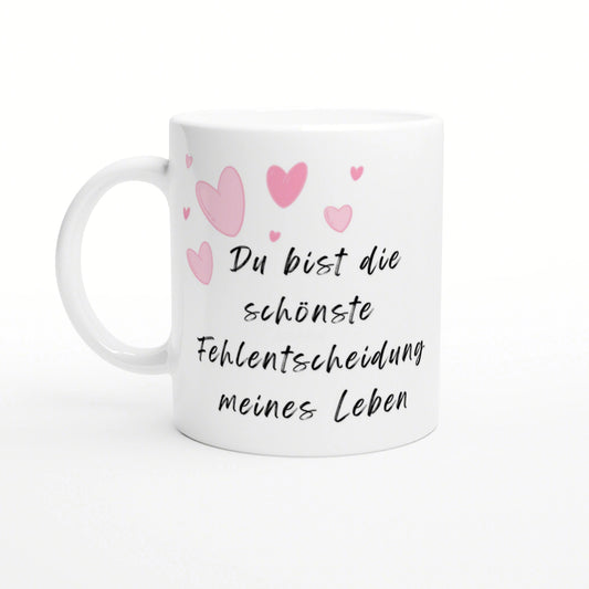 White ceramic mug with pink hearts and black cursive German text: Du bist die schönste Fehlentscheidung meines Lebens.