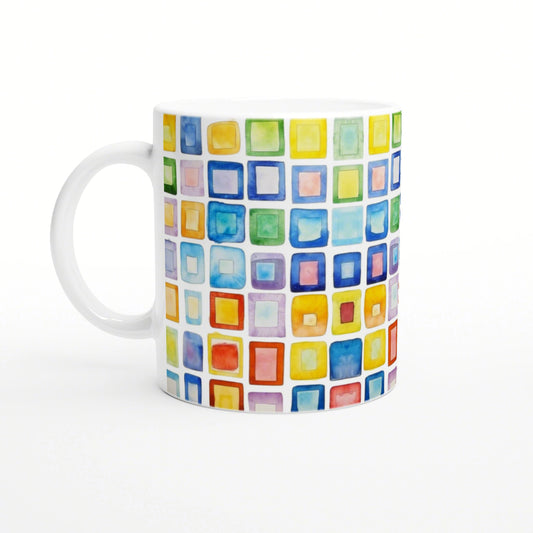 White ceramic mug featuring a vibrant watercolor grid of multicolored squares.