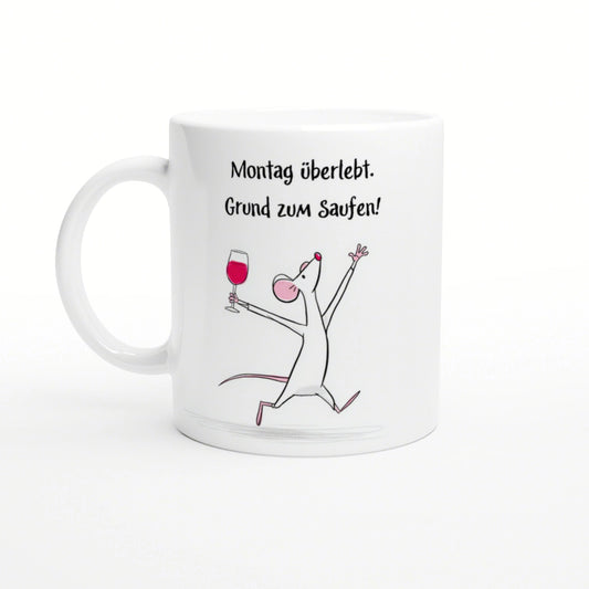 White mug featuring the German slogan 'Montag überlebt. Grund zum Saufen!' with a cheerful cartoon mouse raising a wine glass.