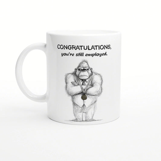 White mug featuring a hand-drawn gorilla in a suit with a medal and the caption Congratulations, you're still employed
