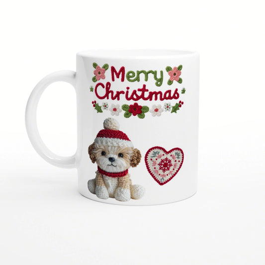 White mug with 'Merry Christmas' knitted text, a crocheted puppy in a red hat and scarf, and a heart motif.