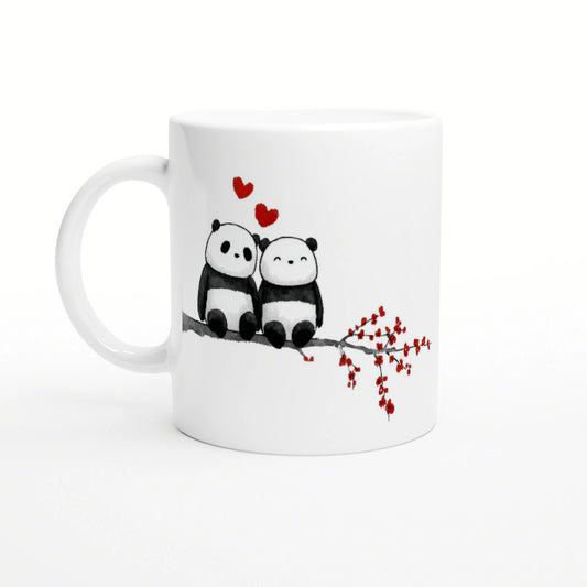 White mug featuring two cuddling pandas on a branch, with red hearts above and a red-flowered twig to the side.
