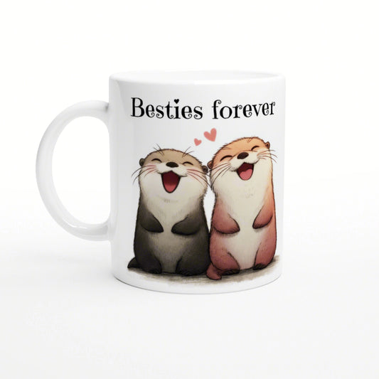 White ceramic mug featuring two smiling cartoon otters side by side, with the caption 'Besties forever' and small pink hearts.
