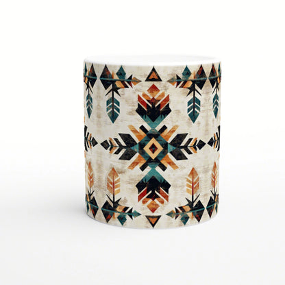 White ceramic mug with a bold geometric Aztec-inspired pattern in teal, orange, and black on a cream background.