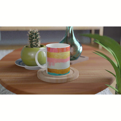 Colorful striped mug on a wooden table with a potted cactus and a glass vase in the background; product mockup for mugs.