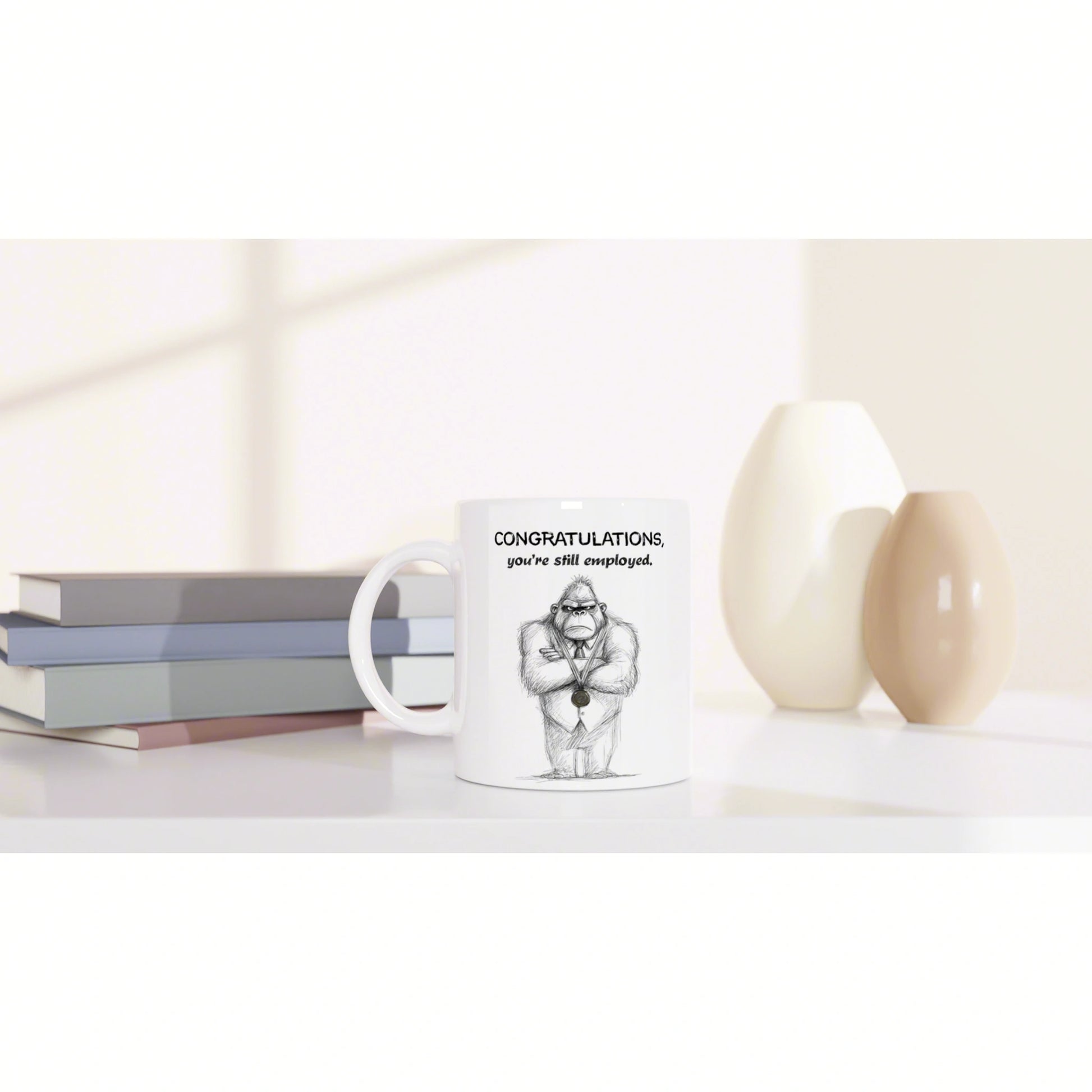 White mug mockup featuring a sketch of a suited gorilla and the caption Congratulations, you're still employed.
