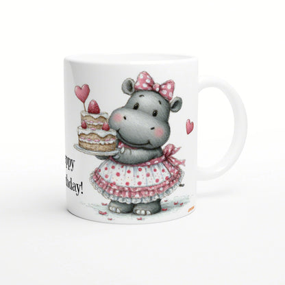 Cute hippo in a pink polka-dot dress and bow holding a layered birthday cake on a white mug.