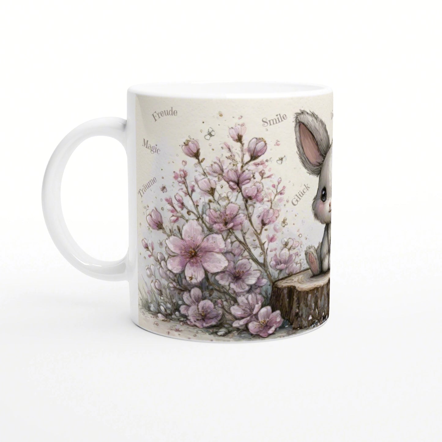Product mockup: white mug with watercolor pink flowers and a cute bunny beside a tree stump on a beige background.