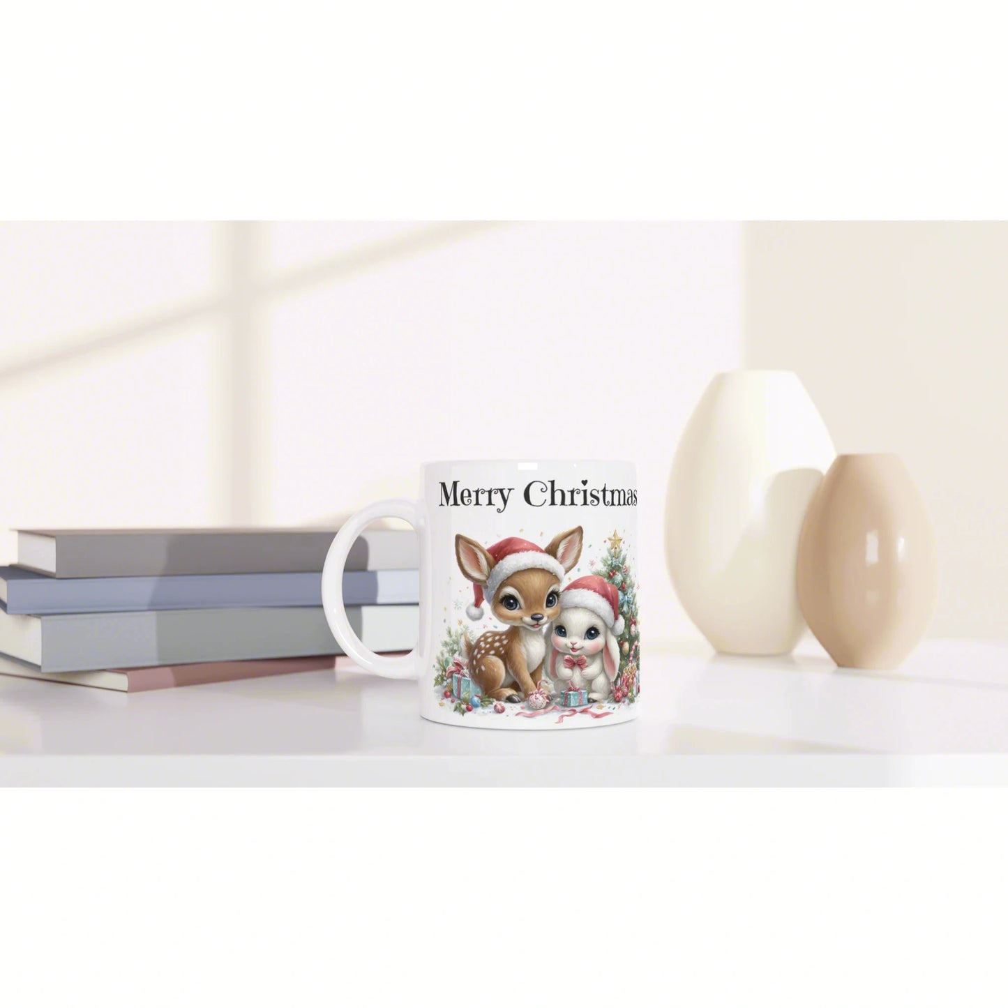 Product mockup: white mug with 'Merry Christmas' showing a cute deer and bunny; books on the left, vases on the right.