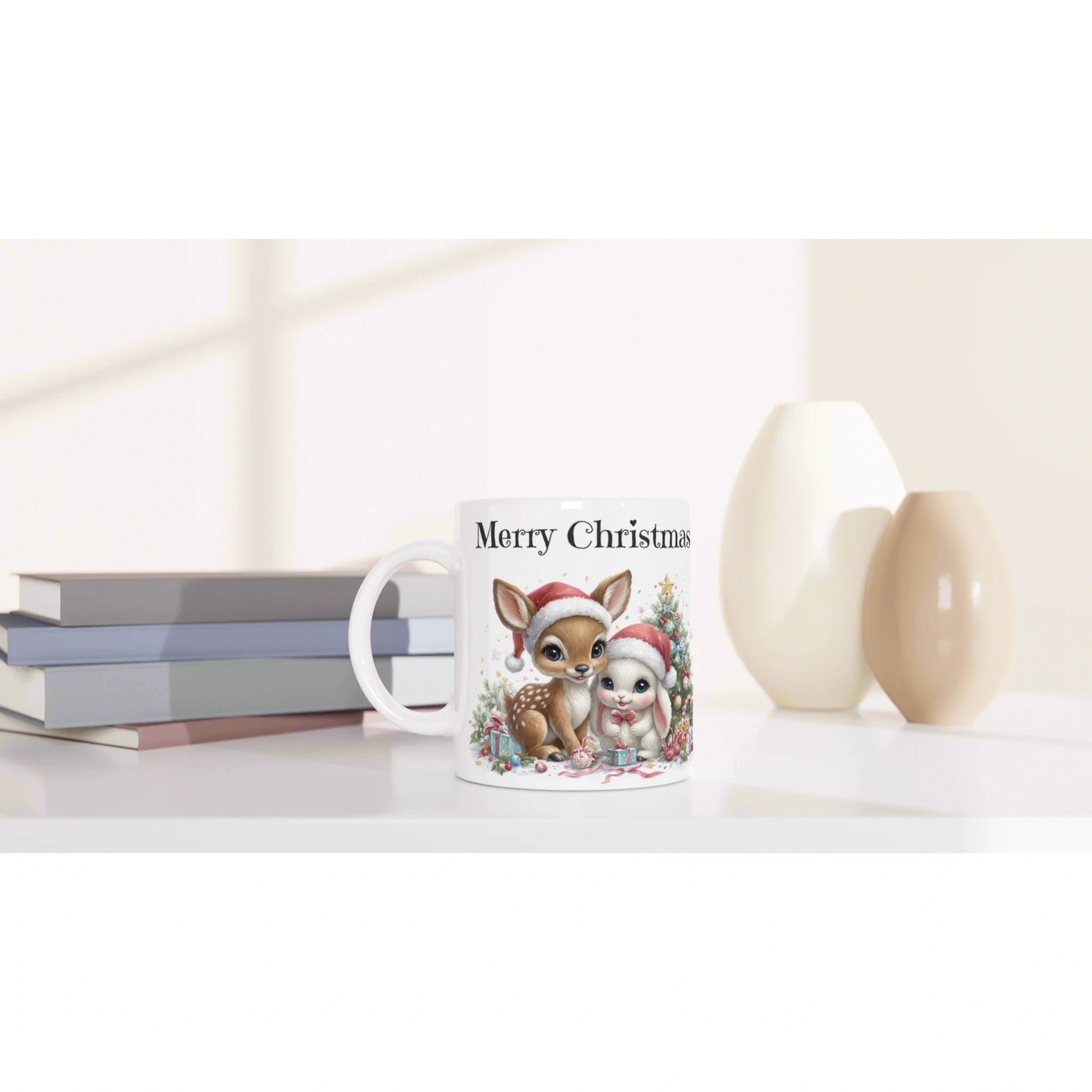 Product mockup: white mug with 'Merry Christmas' showing a cute deer and bunny; books on the left, vases on the right.