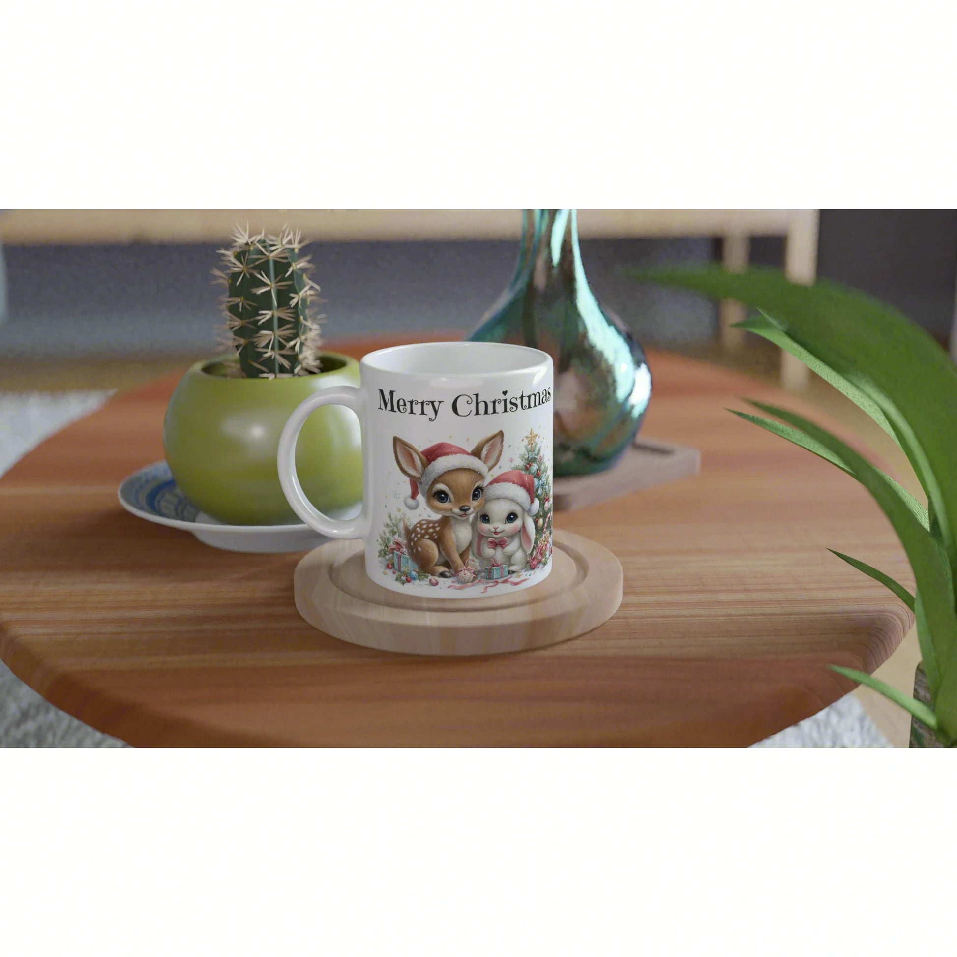 White mug with 'Merry Christmas' featuring a deer and bunny in Santa hats on a wooden table with plants in the background.