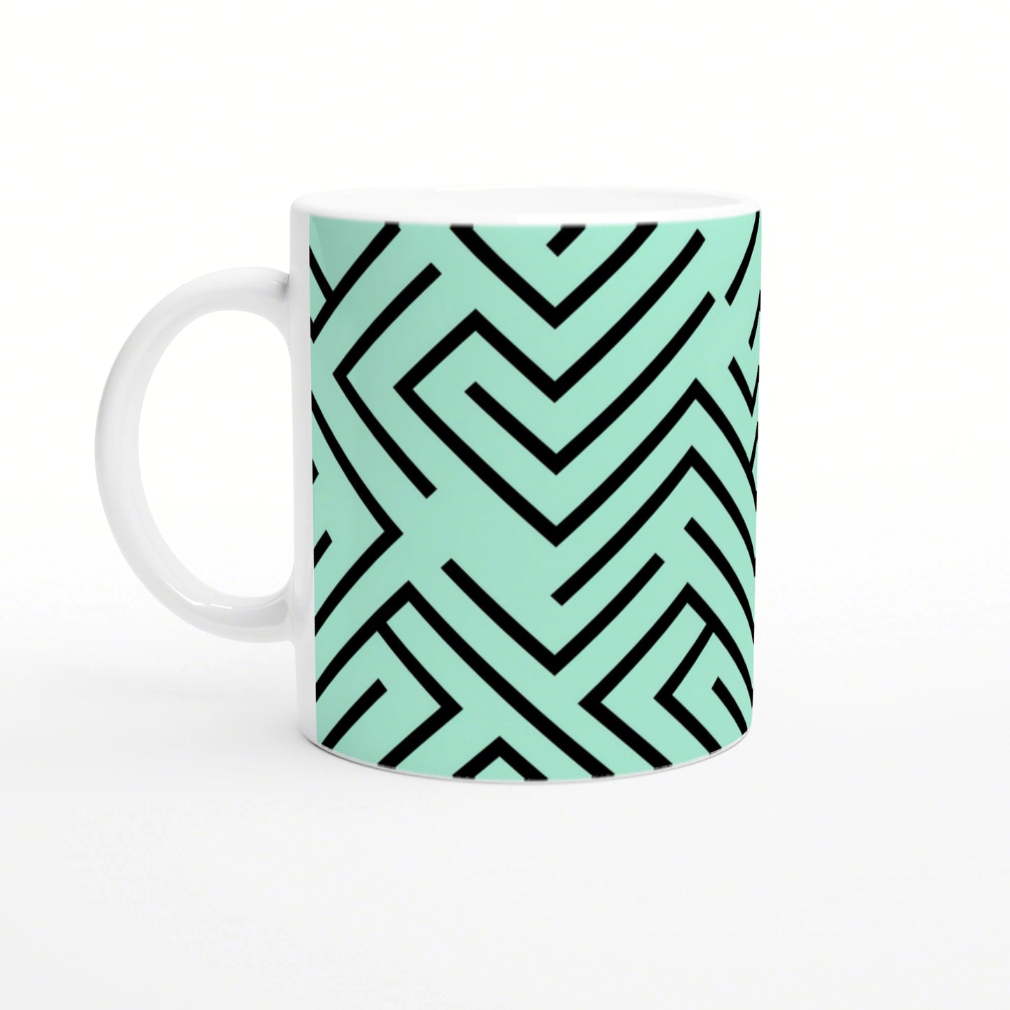 White mug with mint-green wraparound geometric maze pattern in bold black lines.