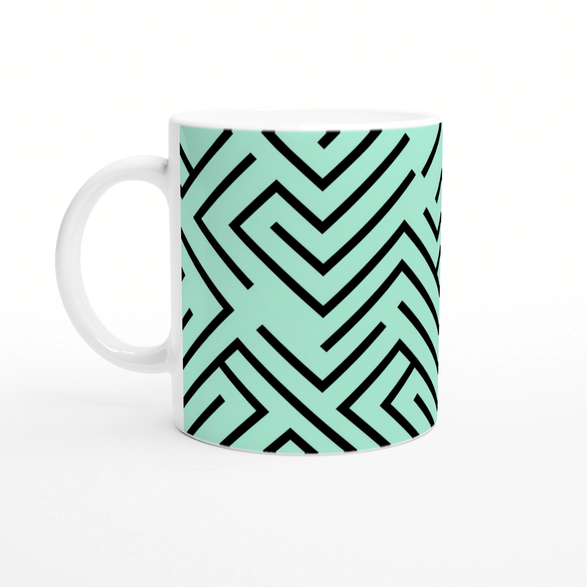 White mug with mint-green wraparound geometric maze pattern in bold black lines.