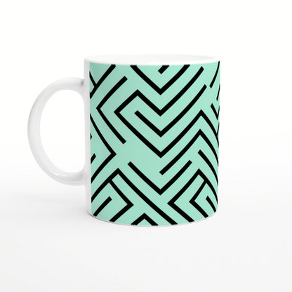 White mug with mint-green wraparound geometric maze pattern in bold black lines.