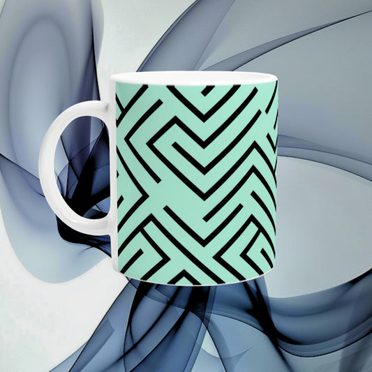 Mint-green mug with a bold black geometric maze pattern; white interior, product mockup for an online shop.
