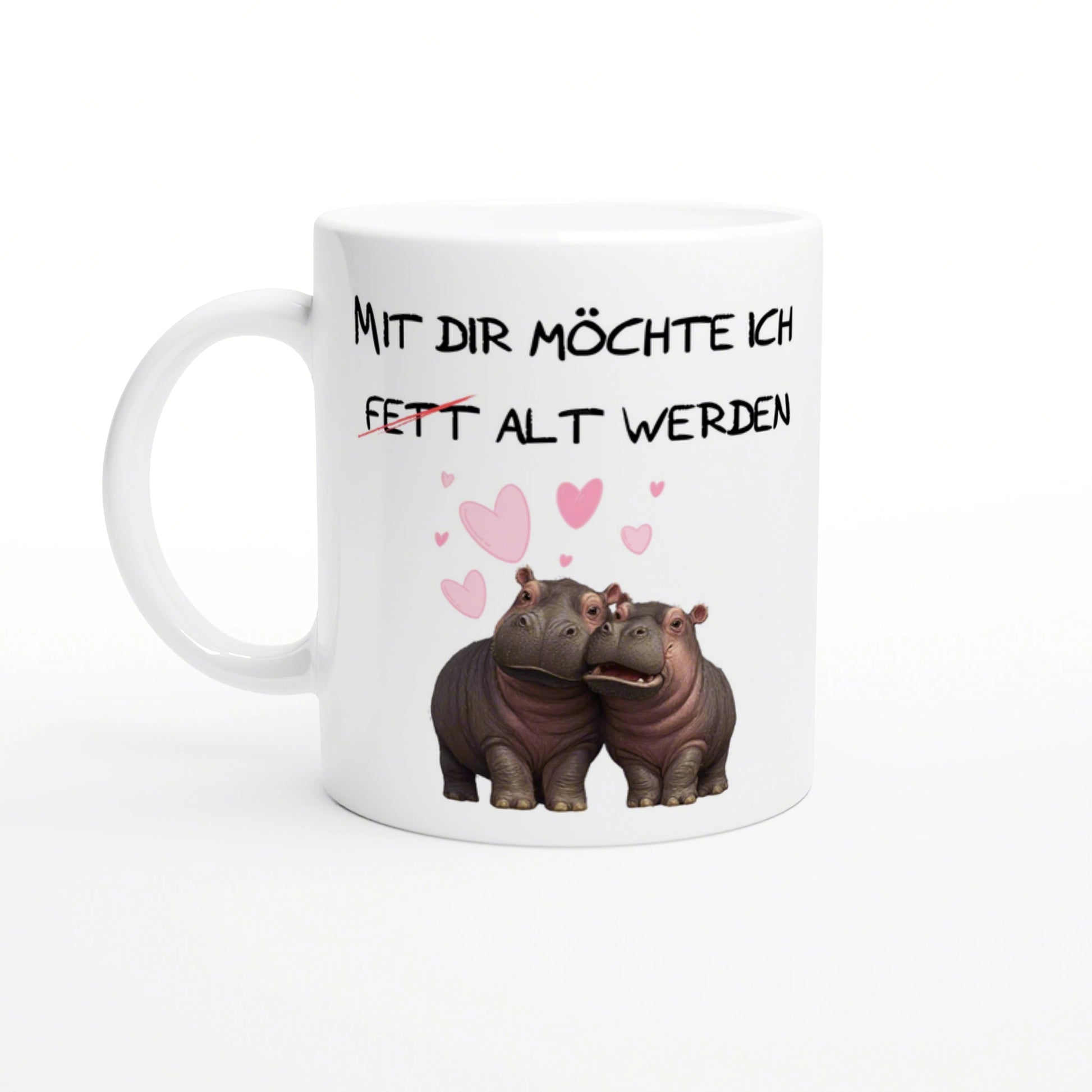 White ceramic mug with black German text Mit dir moechte ich fett alt werden, and two hippos with pink hearts.