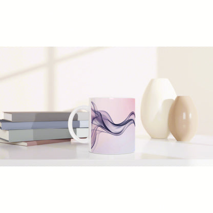 Mockup of a ceramic mug with lavender-purple abstract waves on a pink background, placed on a desk with books and vases