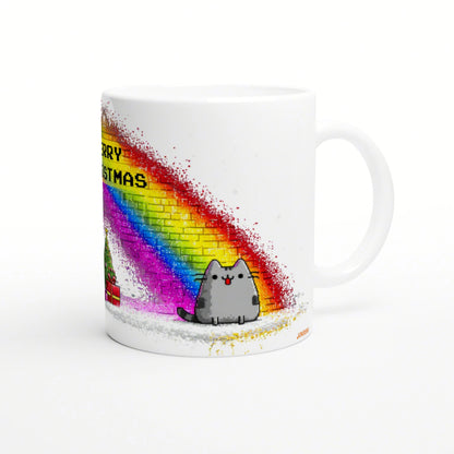 Mockup white ceramic mug with rainbow spray arc, a cute gray cat, and partial 'MERRY CHRISTMAS' text.
