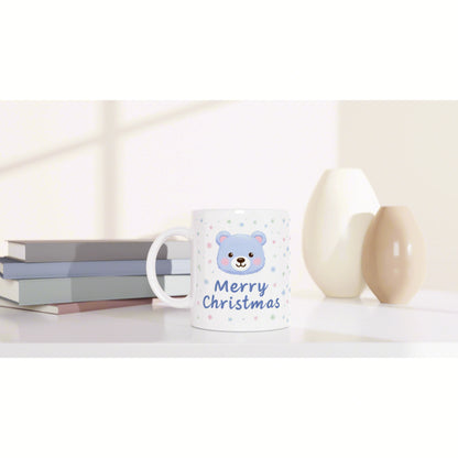 Mug with a blue bear, 'Merry Christmas' text, and snowflakes; pastel books and decorative vases in the background.