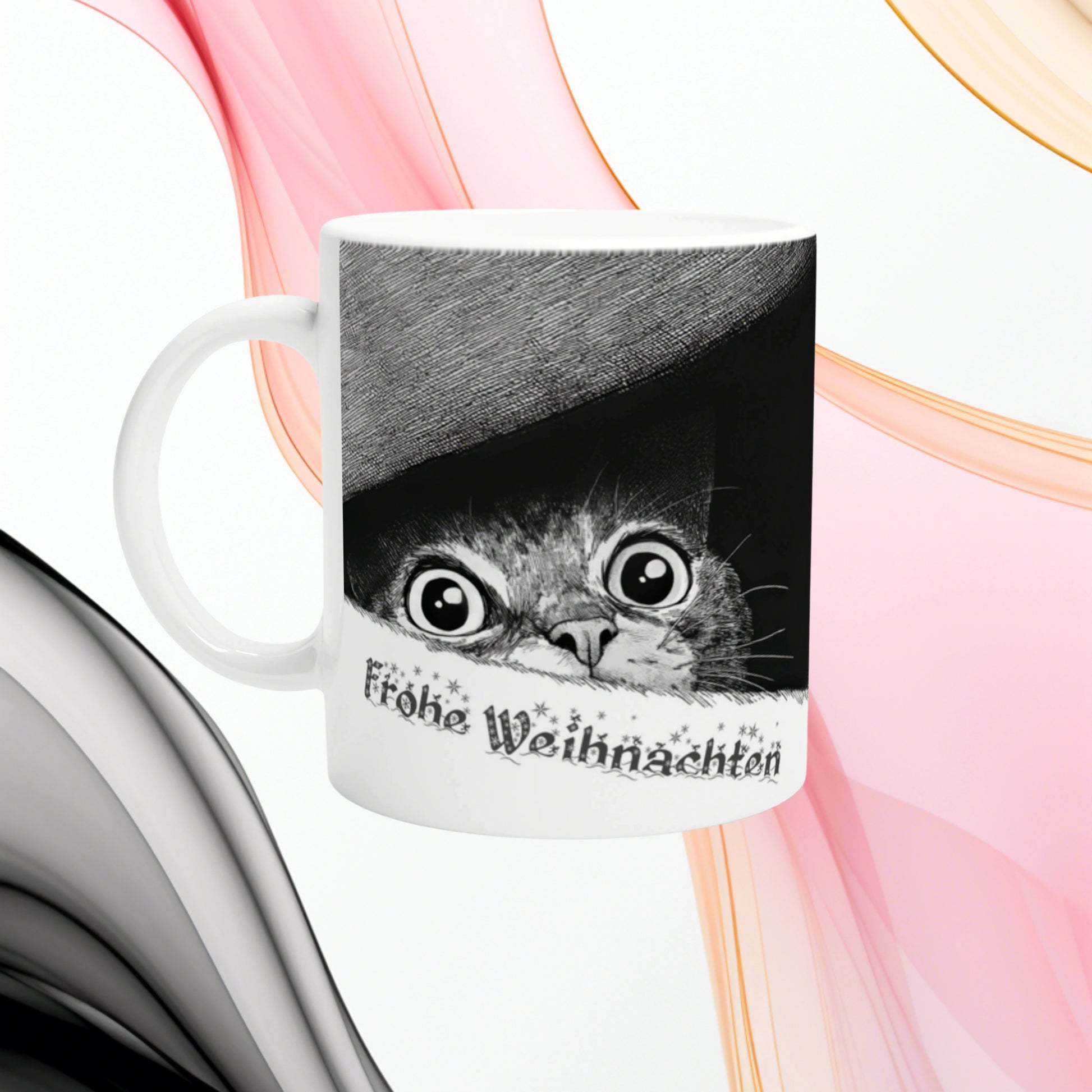 Product mug mockup: white ceramic cup featuring a black-and-white illustration of a wide-eyed cat peeking from under a hat, with 'Frohe Weihnachten' text.
