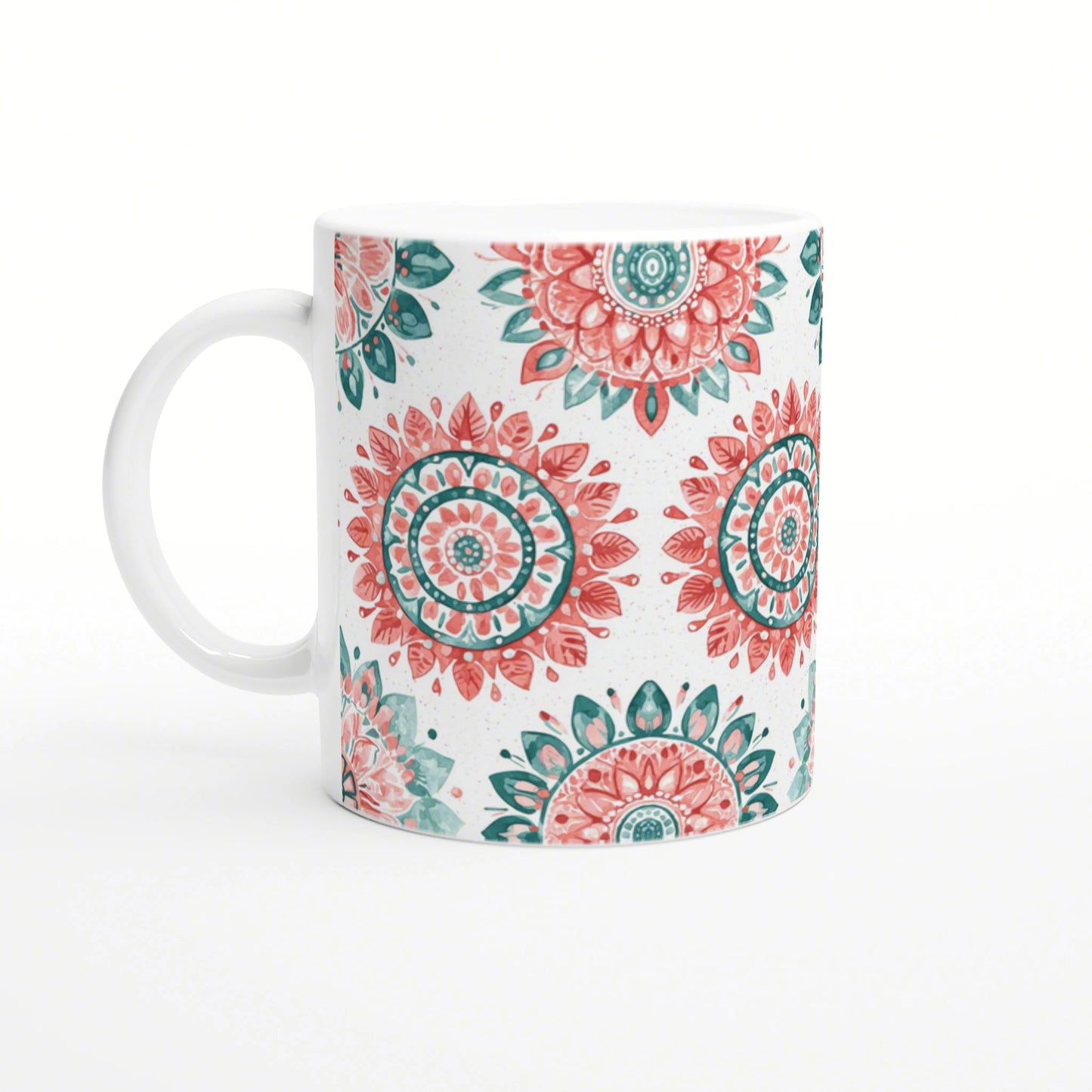 White ceramic mug with coral-pink and teal mandala patterns on a white background; product mockup for a cup in an online shop.