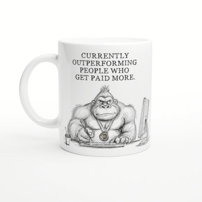 White mug featuring a pencil sketch of a muscular gorilla at a desk, wearing a medal; slogan: Currently outperforming people.