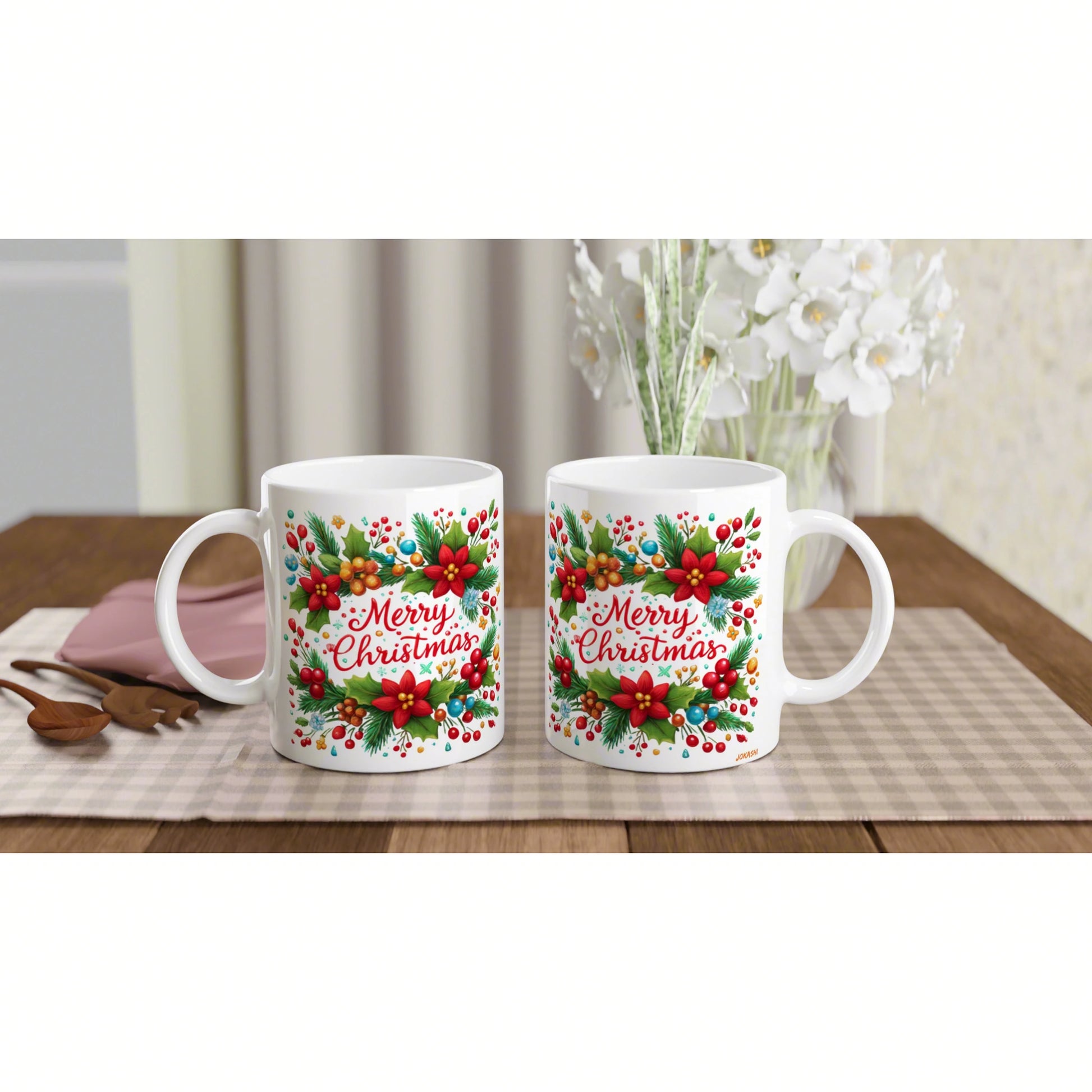 Pair of white ceramic mugs featuring a colorful Christmas floral pattern and the words Merry Christmas on a wooden table.