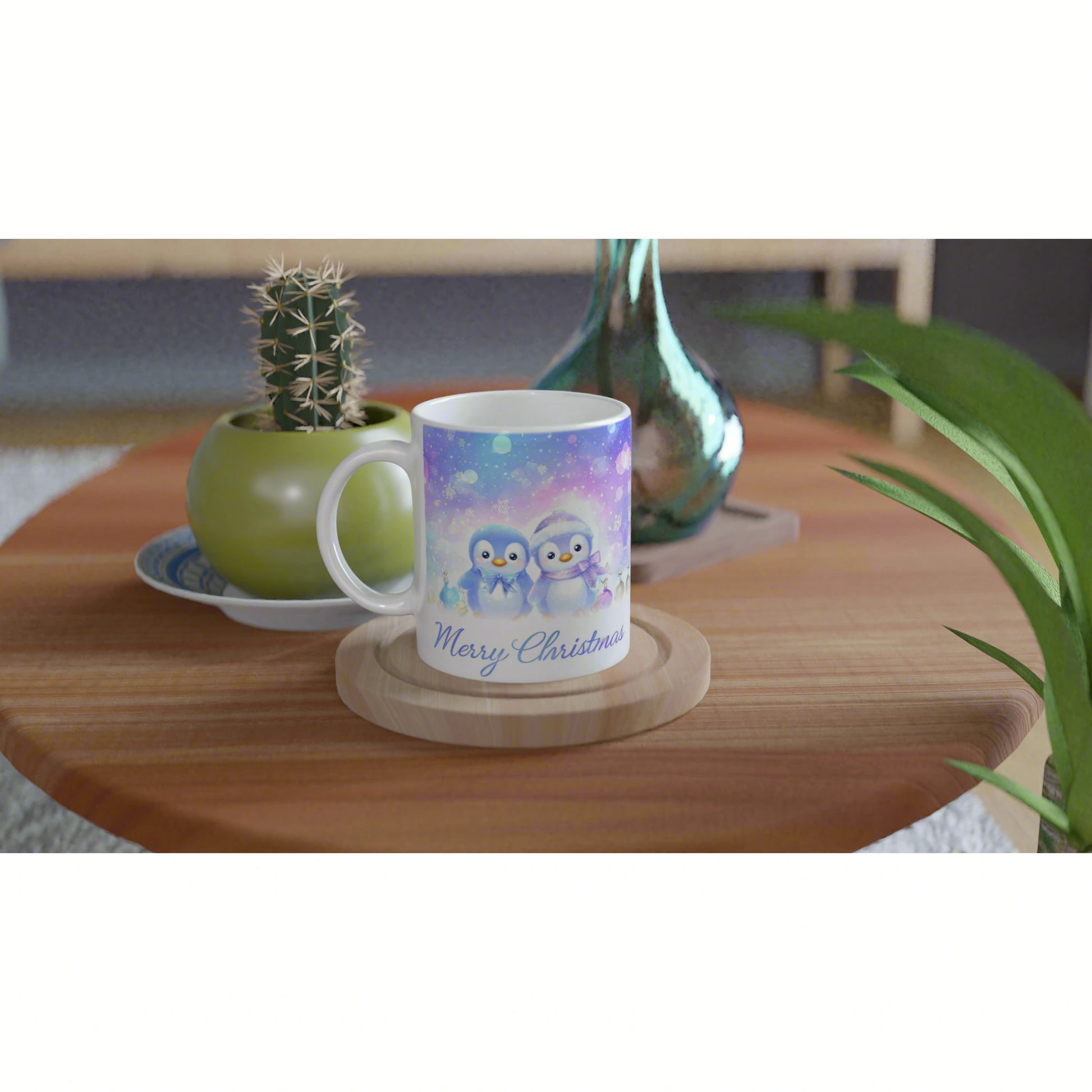 Product mockup: white mug with pastel penguin Christmas scene and 'Merry Christmas' text on a wooden table with nearby plants.