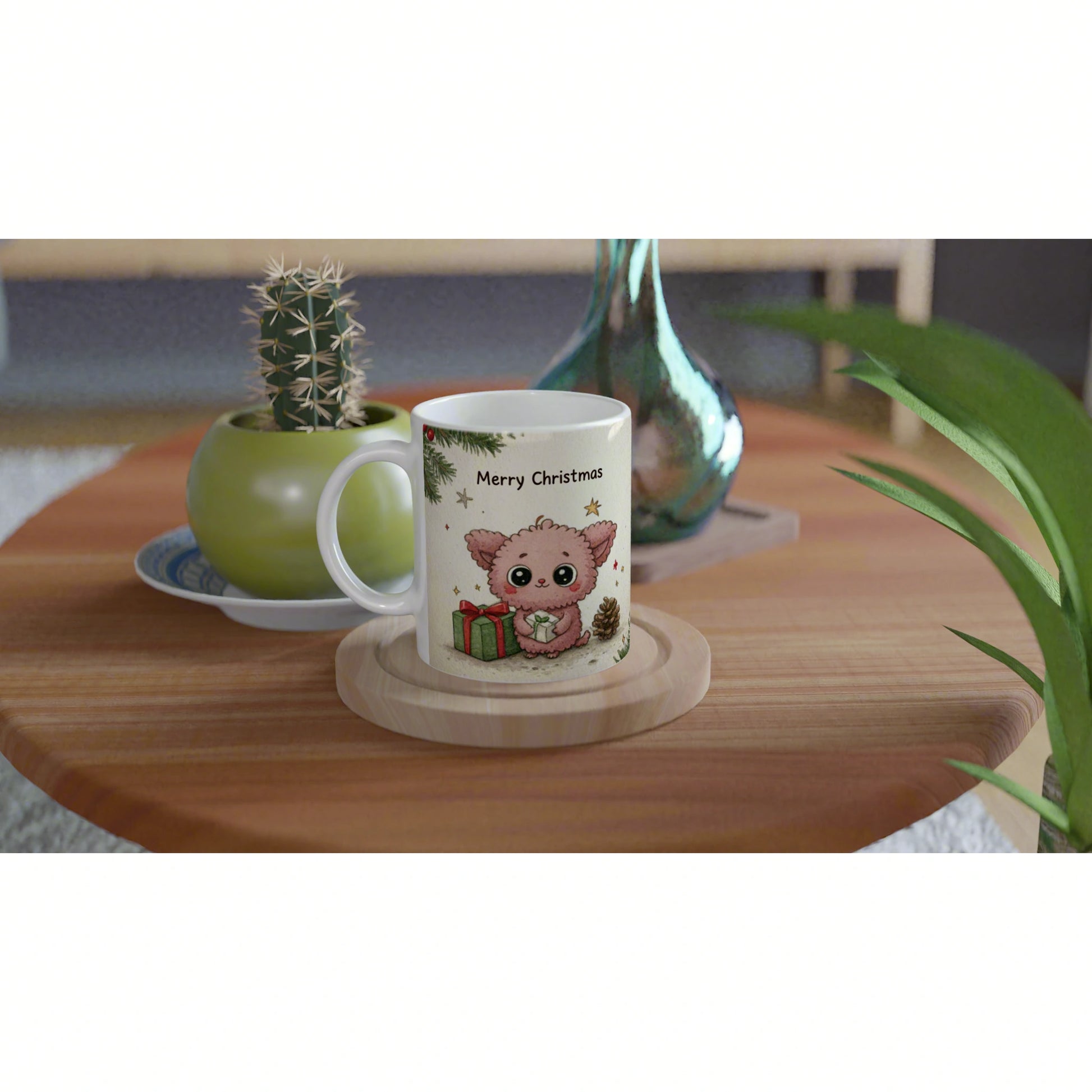 Product mockup: white mug with 'Merry Christmas' and a cute pink cartoon creature holding a gift, on a wooden table.