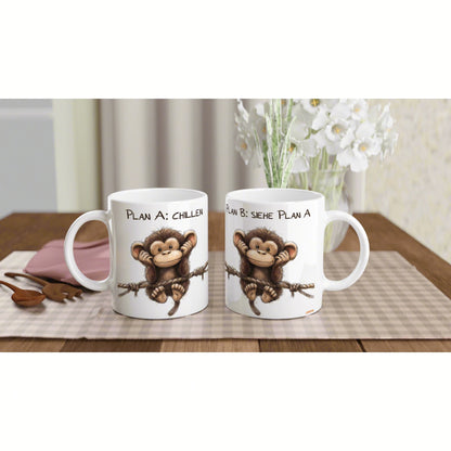 Product mockup: two white mugs with a cartoon monkey on a rope and text Plan A: Chillen / Plan B: Siehe Plan A.