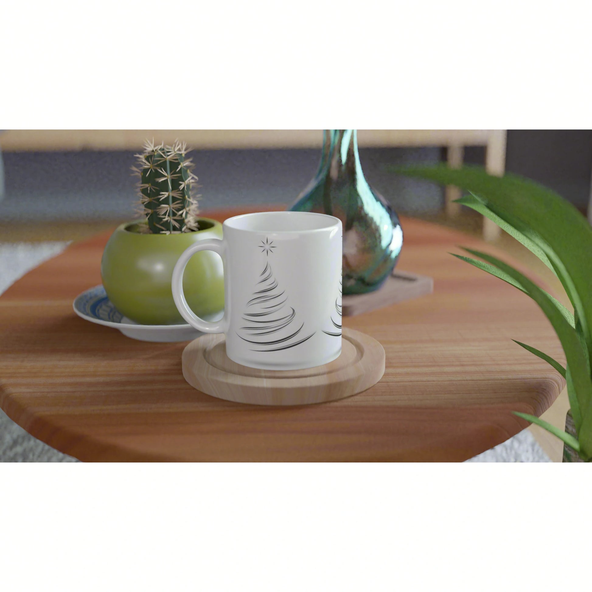 Product mockup: white ceramic mug with a simple black Christmas tree design, on a wooden coaster, placed on a wooden table with plants.