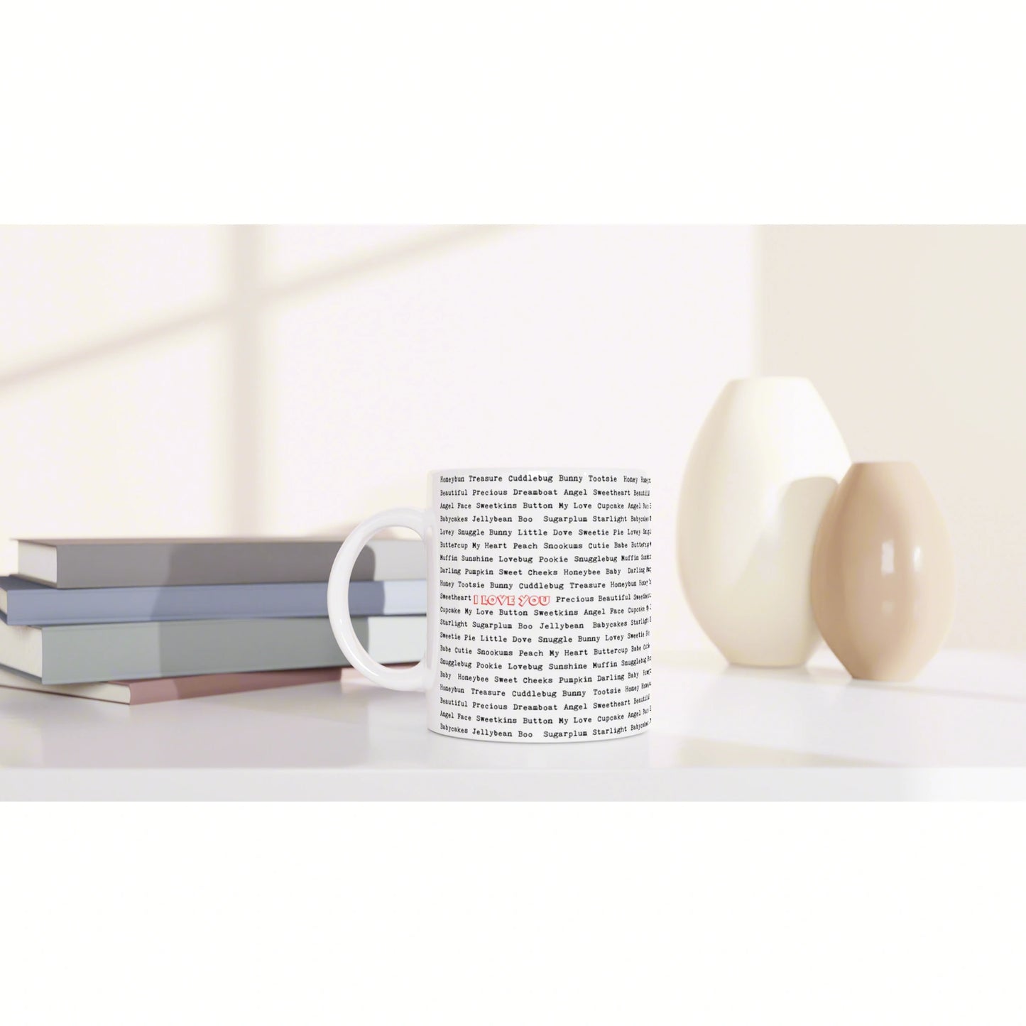 Product mockup: white mug with dense word-pattern print on a white shelf, beside stacked books and beige vases.