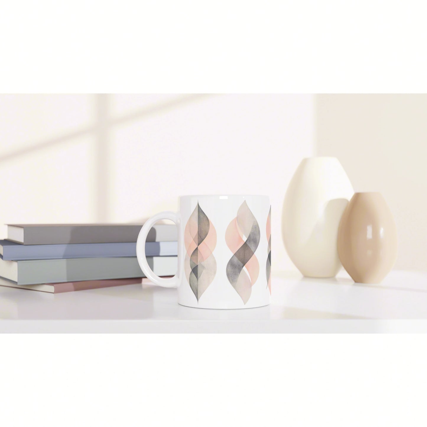 Product mockup: white mug with pastel leaf-pattern design on a shelf beside books and ceramic vases.