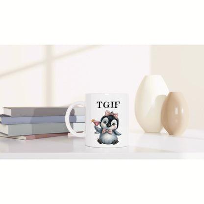 Product mockup: white mug with a penguin wearing a pink bow tie, holding a cocktail and 'TGIF' text, beside books and vases.