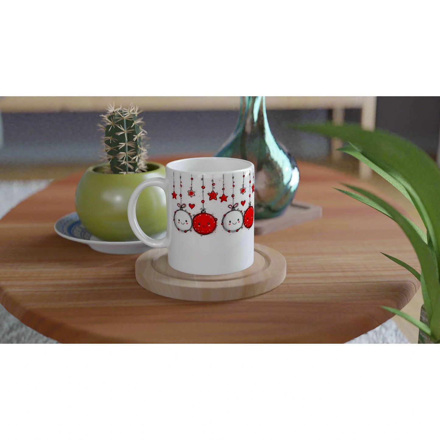 Product mockup: white mug with red-and-white hanging ornament design on a wooden table, beside a cactus pot and vase.