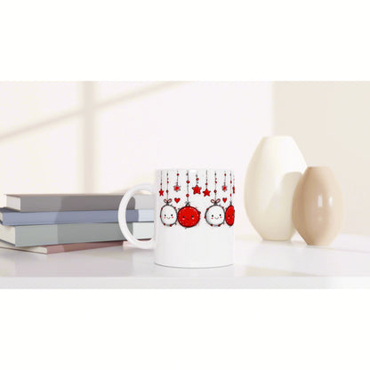 Product mockup: white mug with red hanging ornament design, on a shelf with books and decorative vases.
