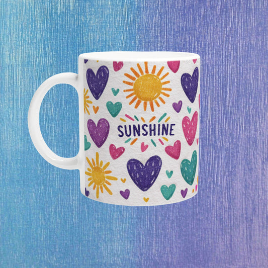 Product mockup: white mug with colorful doodle hearts and suns, the word SUNSHINE, on a textured blue-purple backdrop.