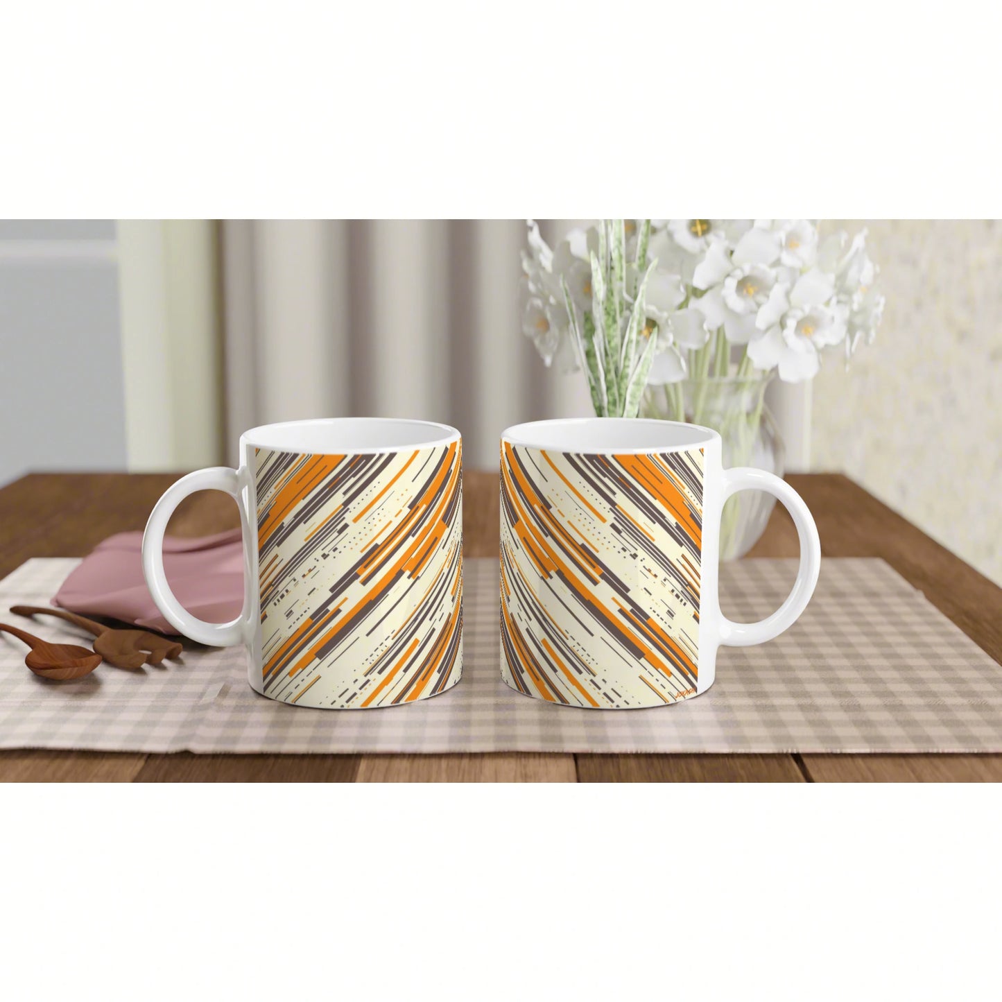 Two ceramic mugs with orange, beige, and black diagonal stripe pattern; product mockup on a wooden table.