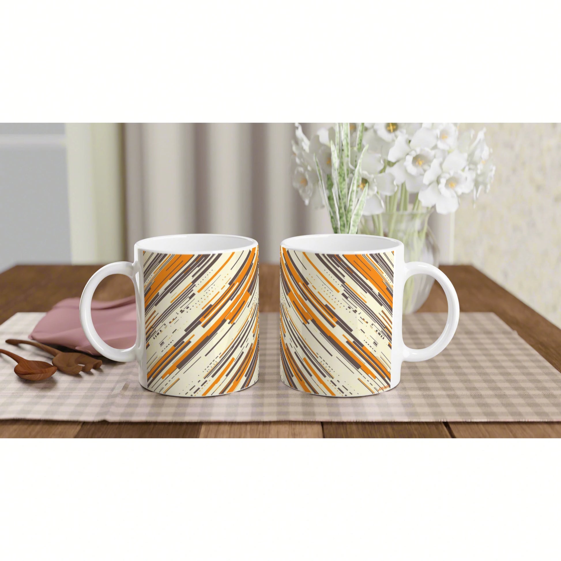 Two ceramic mugs with orange, beige, and black diagonal stripe pattern; product mockup on a wooden table.