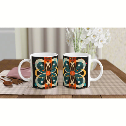 Two white ceramic mugs with a geometric mandala design on black, placed on a wooden table with white flowers in the background.