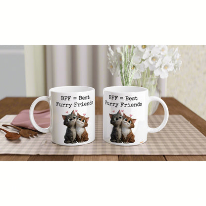 Two white mugs on a wooden table with a checkered placemat, 'BFF = Best Furry Friends' featuring cuddling cats and hearts.