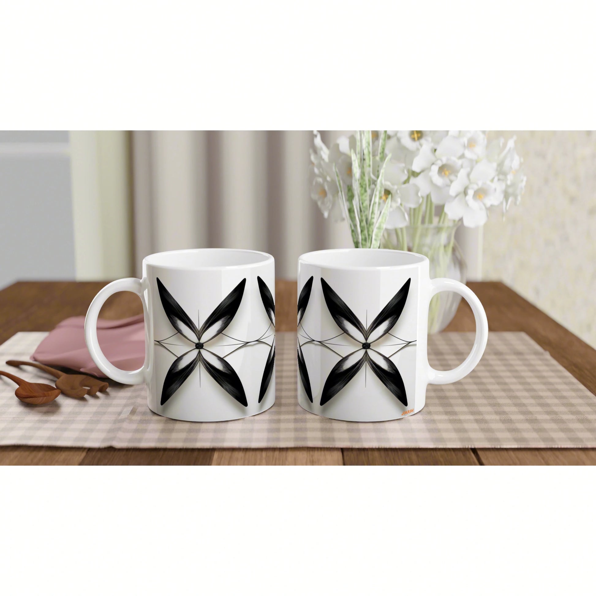 Two white ceramic mugs with a black geometric flower pattern on a wooden table; product mockup for an online shop.