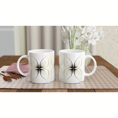Two white mugs with a black petal motif on a wooden table, beige checkered placemat and vase of white flowers product mockup.