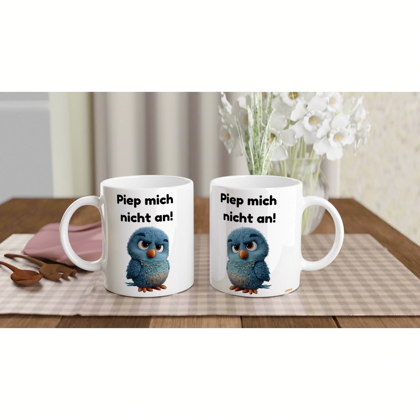 Product mockup: two white mugs on a wooden table featuring a cute blue bird and the German phrase 'Piep mich nicht an!'